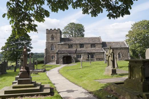 Altham St James Church pictured behind the churchyard