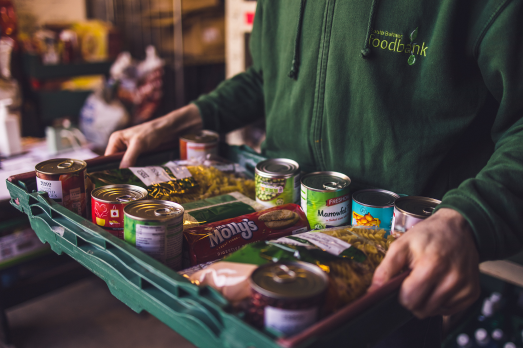 A box of food being held by a pair of anonymous hands