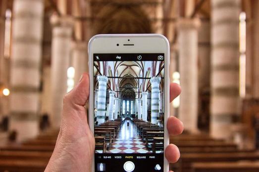 A phone being held up to take a photo inside a church