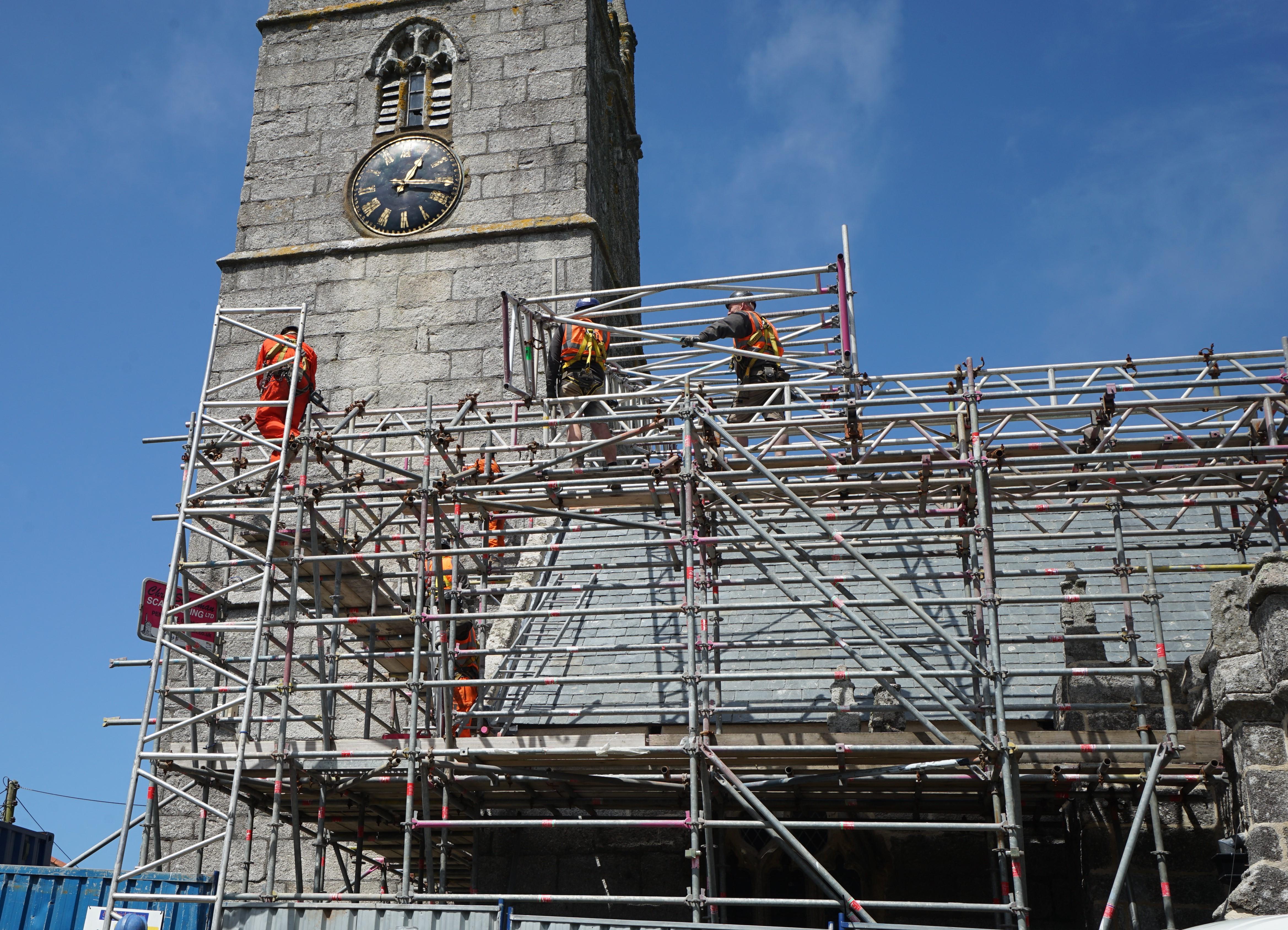 Image of workmen on scaffolding around a church