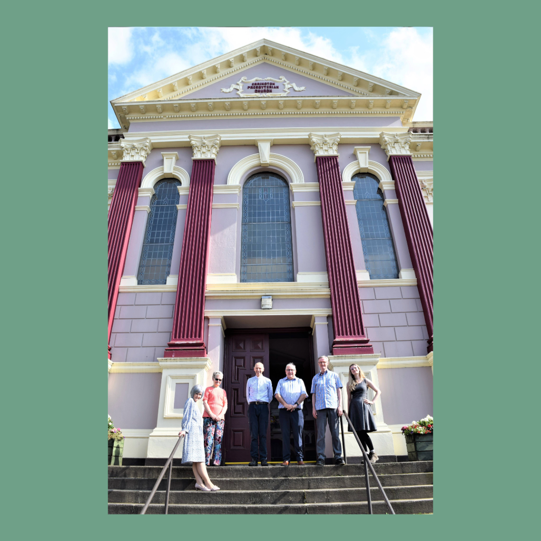 A group of people standing on the steps outside a church