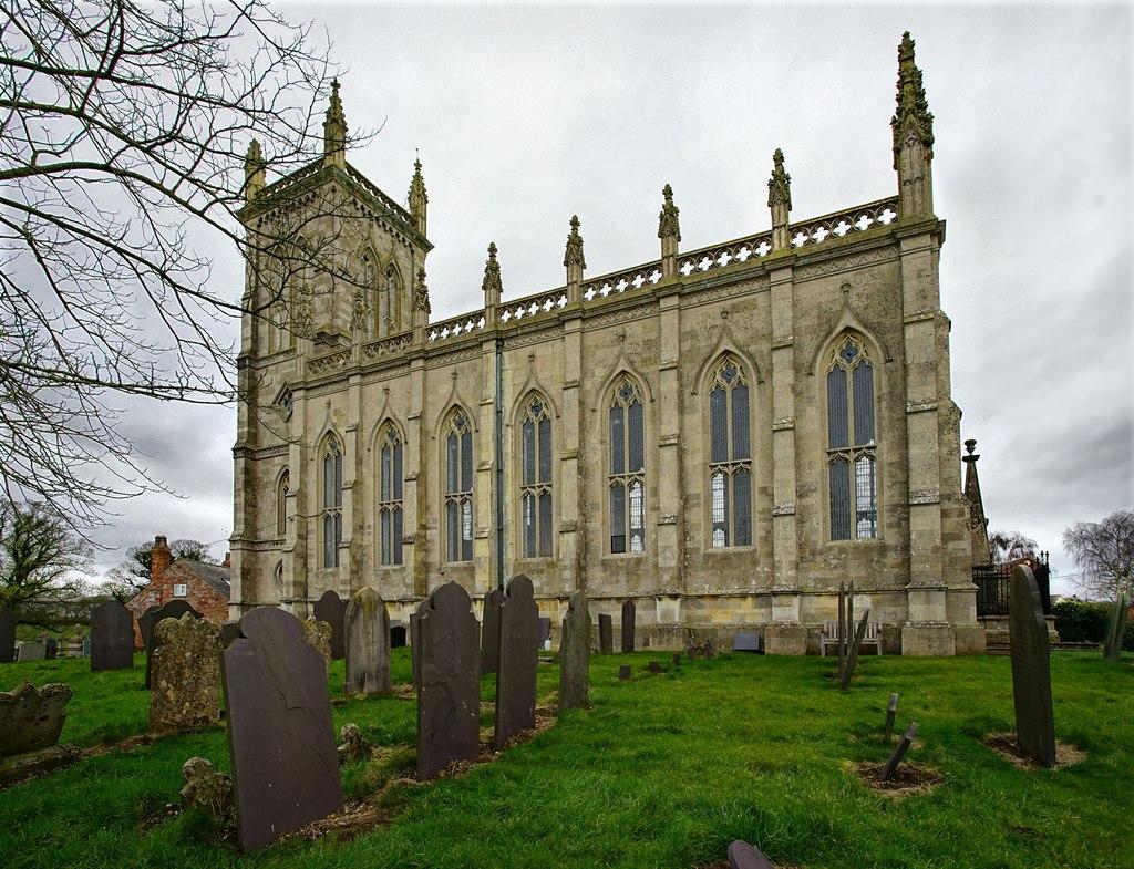 A church pictured from the side, with tall windows.