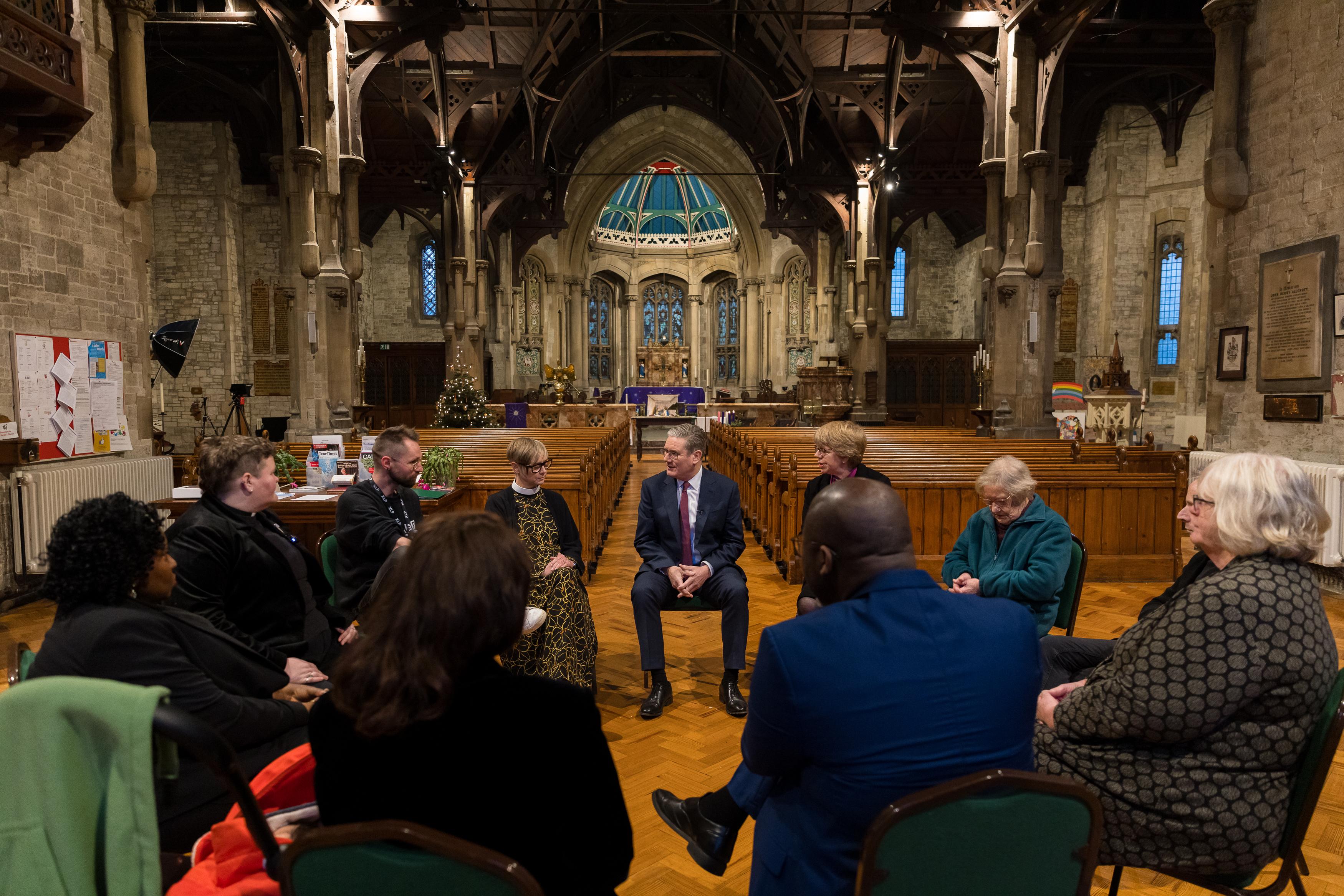 Keir Starmer sits in a circle of people inside a church