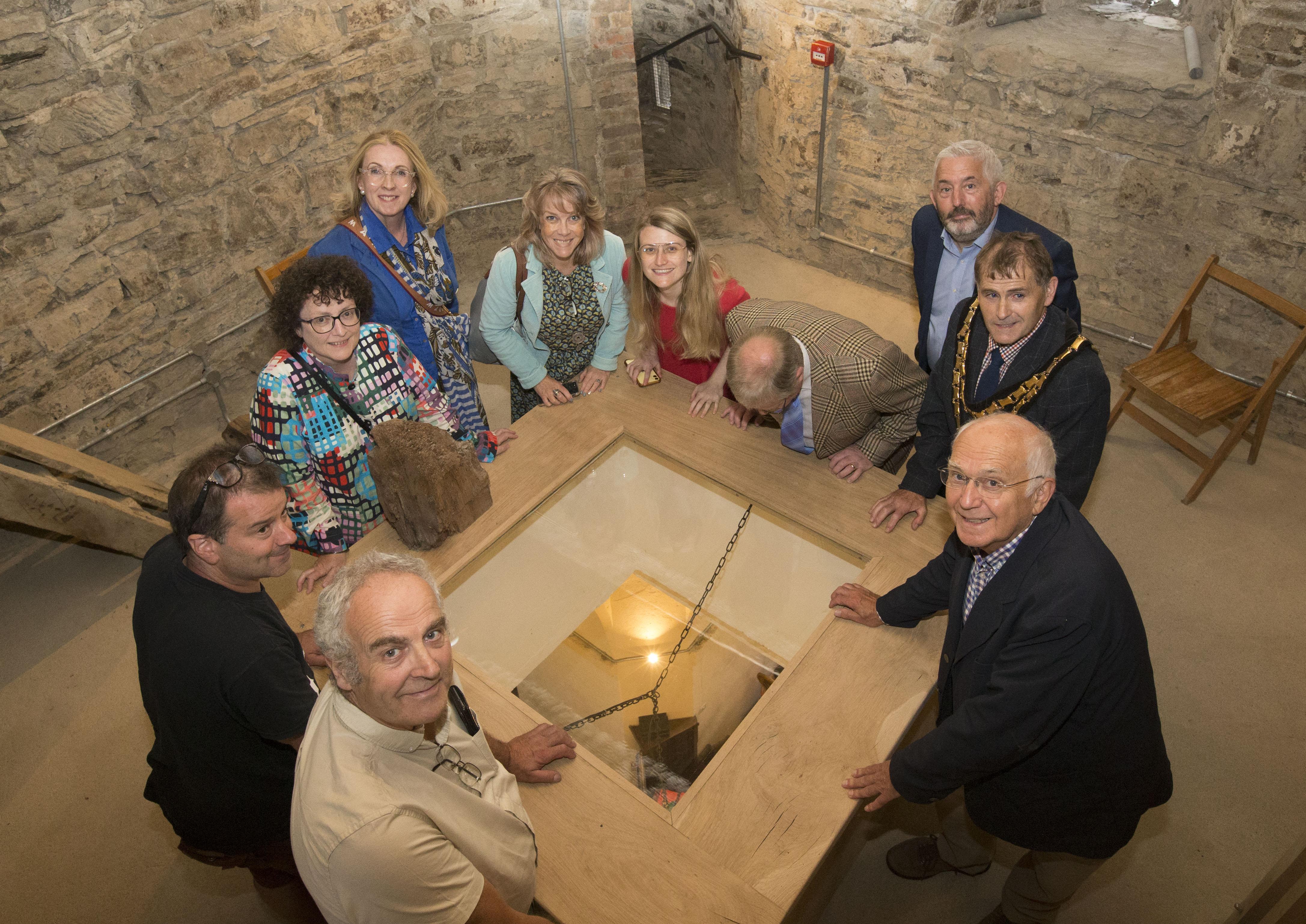 Taken on the 1st floor of the tower around a glazed viewing hatch with people looking down onto the ground floor of the church. 