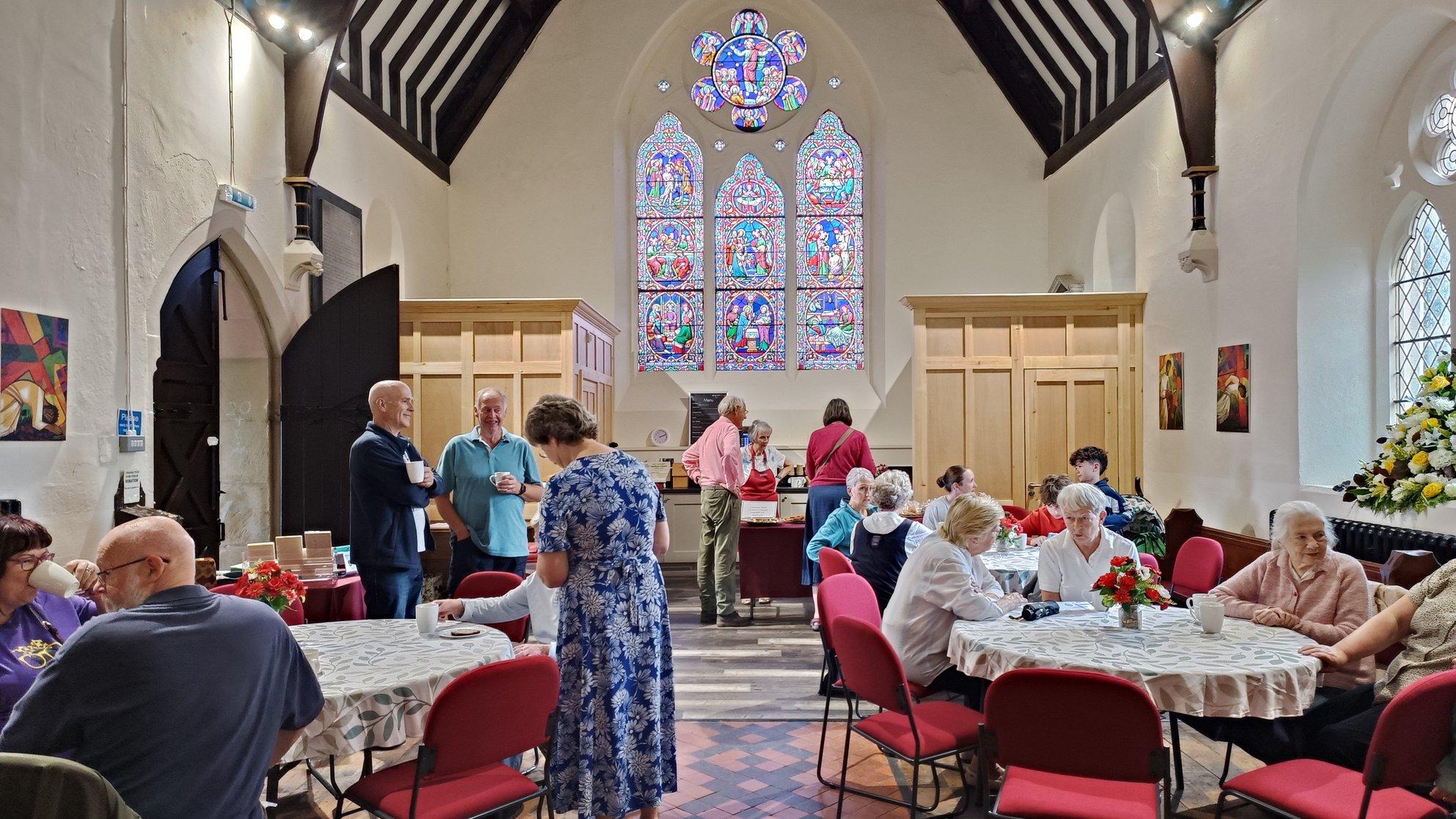 People sitting at tables inside a church