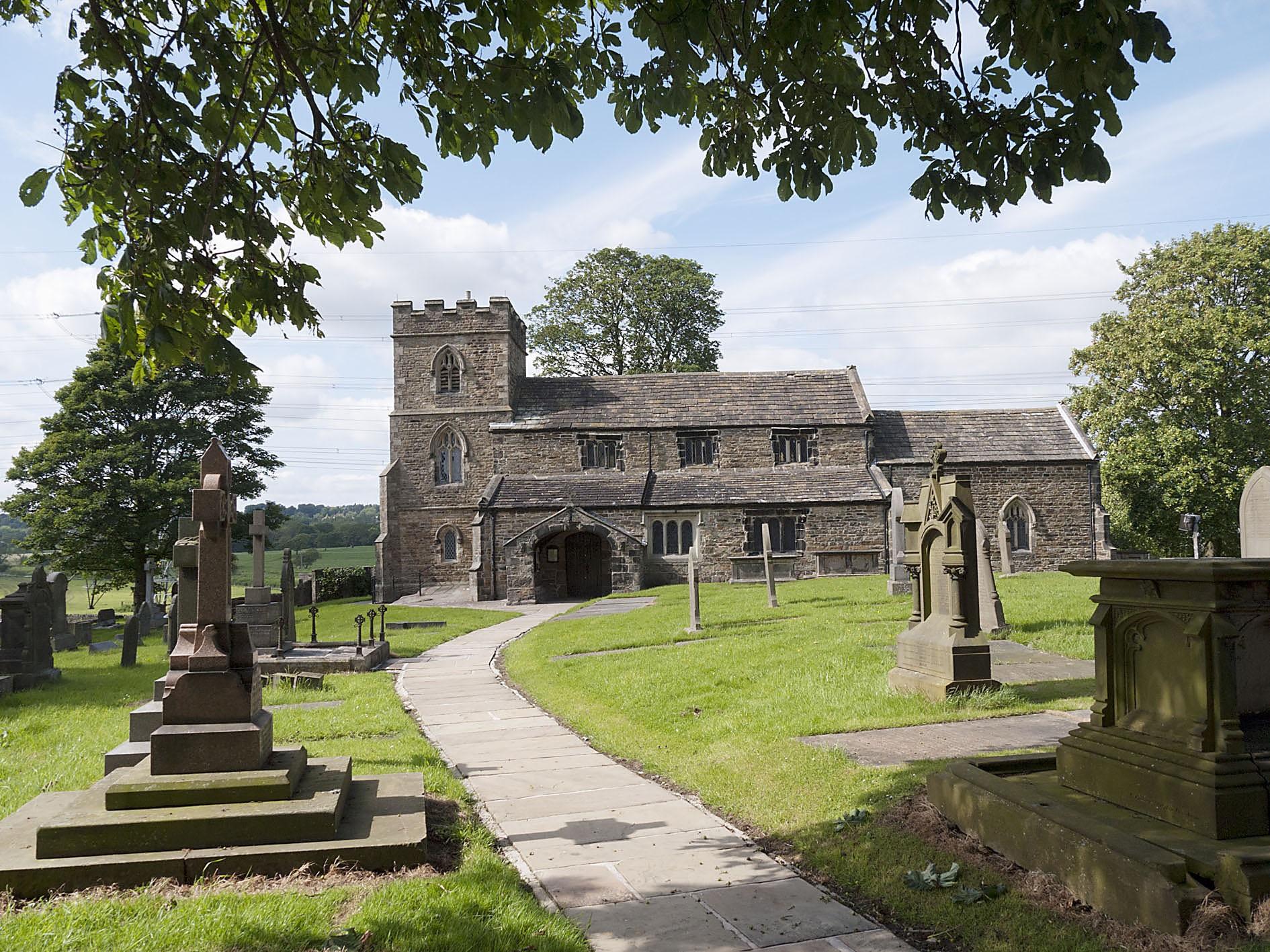 Altham St James Church pictured behind the churchyard