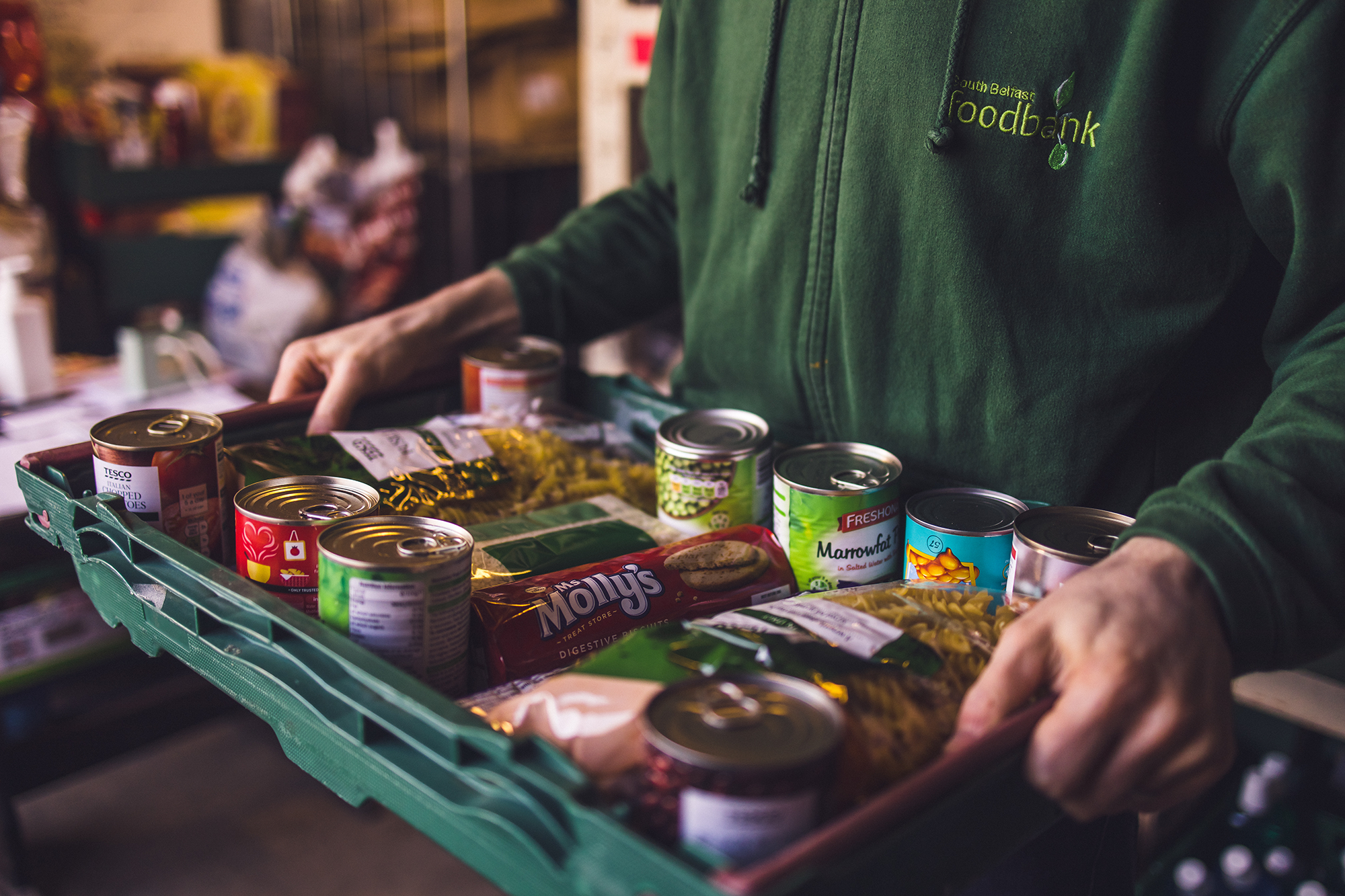 A box of food being held by a pair of anonymous hands