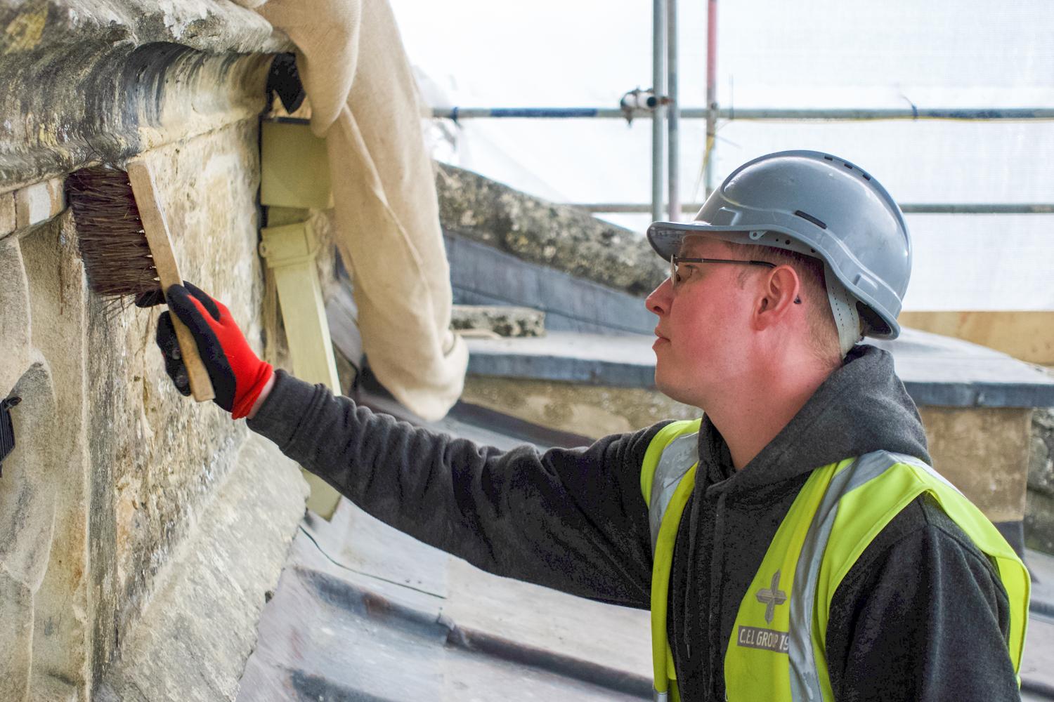 A photograph of a man brushing a wall