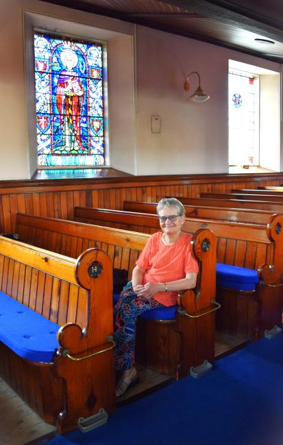 A woman sitting on a pew inside Ebrington Presbyterian Church