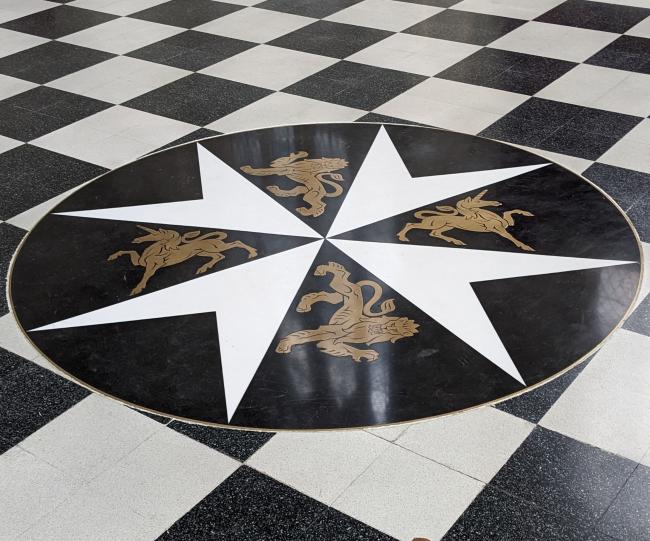 A large eight-pointed cross on the floor of a church