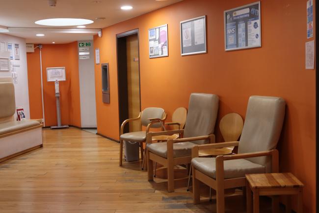 A waiting room with five chairs against a wall