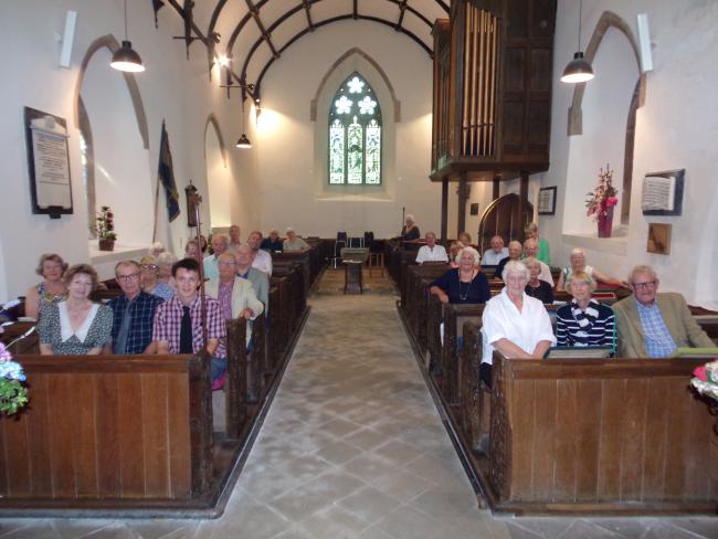 A congregation sitting in pews at a church, facing the camera