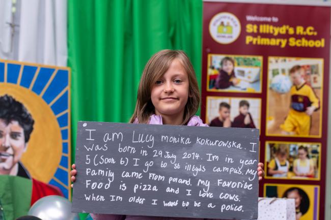 A girl holding a slate with writing on it