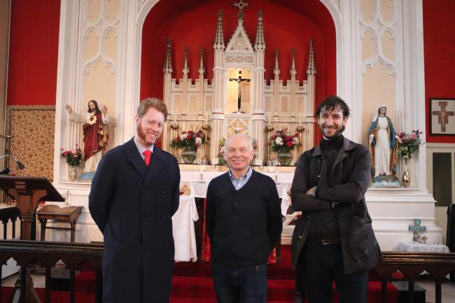 Three people standing inside a church